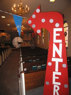 the interior of a church with rows of pews and chandeliers hanging from the ceiling