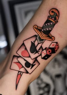 a tattoo with playing cards and dice on the arm