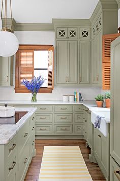 a kitchen with green cabinets and white counter tops is featured in the home design idea magazine