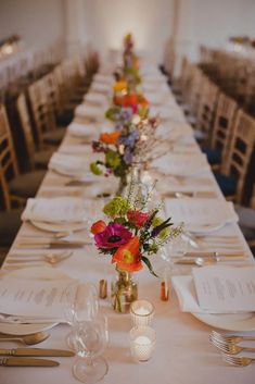 a long table is set with flowers and place settings