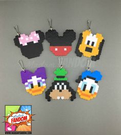 six different colored mickey mouse keychains hanging from hooks on a gray surface with an advertisement for disney world in the background