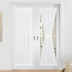 an open white door with sheer curtains on it