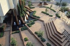 an aerial view of a courtyard with stairs and water features in the center, surrounded by greenery