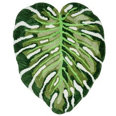 a green and white heart shaped rug with a leaf pattern on the bottom, in front of a white background