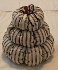 a stack of pillows sitting on top of a white tablecloth covered floor next to a wall