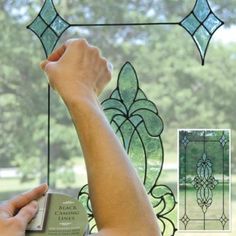 a person is holding up a stained glass window