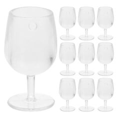 a bunch of wine glasses sitting next to each other on top of a white surface