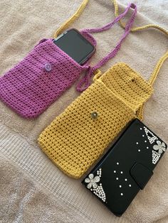 two crocheted purses sitting on top of a bed next to each other