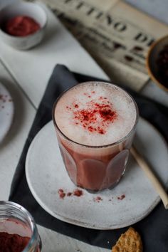 a drink is sitting on a plate next to some cookies