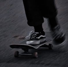 a person riding a skateboard down a street with their feet on the board and one foot in the air