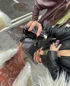 a woman in black leather jacket playing an electric guitar on the street with other people