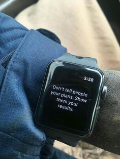 a person wearing a smart watch with a message on the screen saying don't tell people your plans, show them your results