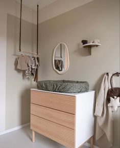 a baby crib in the corner of a room next to a mirror and coat rack