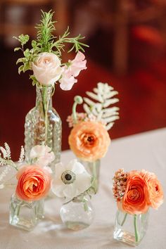 three glass vases with flowers in them on a table