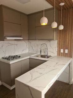 a kitchen with white marble counter tops and brown cabinets