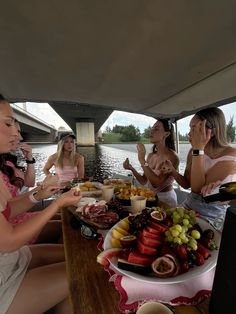 four women sitting at a table with plates of food and drinks in front of them