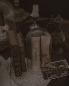 some books and candles are on a table