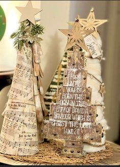 two wooden christmas trees sitting on top of a table next to each other with musical notes written on them