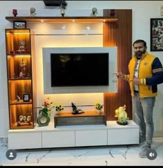 a man standing in front of a flat screen tv on a wall mounted entertainment center