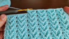 someone is crocheting the stitchs on a blue blanket