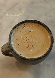 a cup of coffee sitting on top of a table