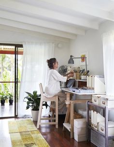 a woman sitting at a desk working on a laptop