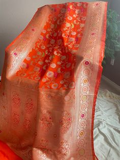 Banarasi pure katan silk saree in Sona Rupa zari weaving all over the body and Tilfi meenakari weaving on the border. Comes with a plain blouse with zari border. Maintenance: Dry wash advisable Returns and refund only accepted on defective products. Product should be shipped back in 3 days after delivery . Please go through our return policies below. Our Policy on Returns, refunds and exchanges: We don't accept requests for returns and exchanges on the below observations: non-defects: Small knot Orange Banarasi Silk Saree With Meenakari, Orange Tussar Silk Wedding Dupatta, Orange Meenakari Traditional Wear For Puja, Orange Tussar Silk Traditional Wear For Diwali, Orange Tussar Silk Dupatta For Wedding, Orange Traditional Wear With Meenakari For Puja, Festive Orange Katan Silk Traditional Wear, Wedding Orange Tussar Silk Dupatta, Orange Tussar Silk Saree With Zari Weaving