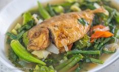 a white bowl filled with fish and vegetables