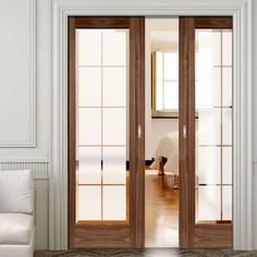 an open glass door in the middle of a room with white walls and wood floors