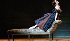 a woman in a blue dress sitting on a bench