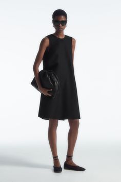 This simple mini dress rings true to the considered design ethos at COS. Offered in a perennial black hue, it's styled in a clean A-line silhouette and has an enthraling twist detail that frames the V-back. It is crafted from a TENCEL™ Lyocell and linen blend that's light in balmy weather. Relaxed fitSide seam pocketsTENCEL™ is a trademark of Lenzing AG. TENCEL™ Lyocell is made from renewable wood sources, using a process that recycles 99% of all chemicals and water  Shell: 77% TENCEL™ Lyocell, 23% Linen. Excluding trims / Machine wash Back length of size 6 is 95.3cm / Model wears a size 6 Simple Mini Dress, Glamorous Fashion, Denim Sweater, Dress Rings, Glamour Fashion, Wool Dress, New Arrival Dress, Simple Dresses, Mini Black Dress