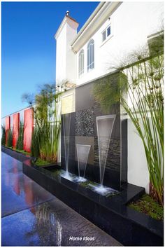 an outdoor water feature in front of a house