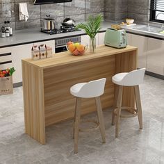 a kitchen with two stools next to a counter and an island in the middle