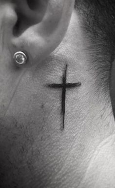 a man's neck with a cross tattoo on it