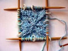 two knitting needles are hooked up to an object that looks like something out of yarn