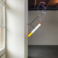 a white room with a light that is on the wall and some wires hanging from it