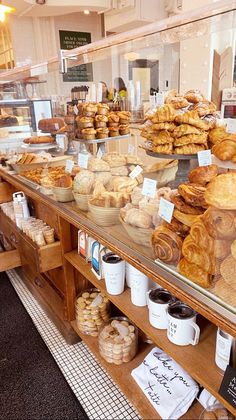 a bakery filled with lots of different types of breads and pastries on display