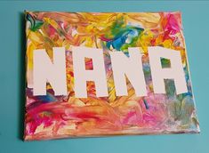 a painting with the word nann painted on it in white letters and multicolored acrylic paint