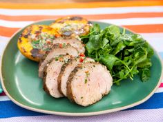 some meat and greens on a green plate