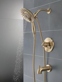 the shower head and handset are connected to the wall with water running from it