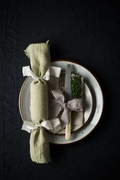 a place setting with napkins, fork and knife on a black tablecloth background