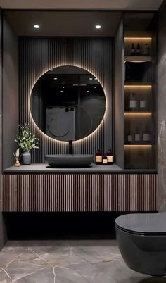 a bathroom with a round mirror above the sink and a black bathtub in front of it