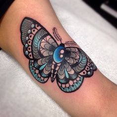 a colorful butterfly tattoo on the arm