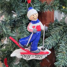 a christmas ornament hanging from a tree with a skier on it's back