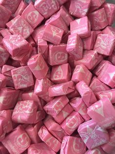 a pile of pink and white candy cubes with the word love written on them