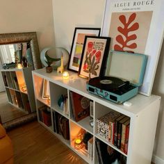 there is a book shelf with books and pictures on it