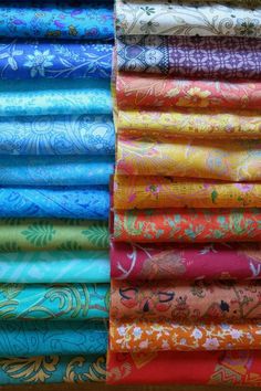 many different colored fabrics are stacked on top of each other