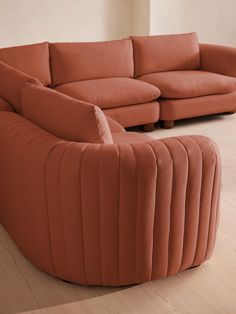 an orange couch sitting on top of a hard wood floor