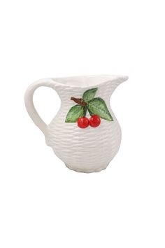 a white vase with cherries and leaves on it