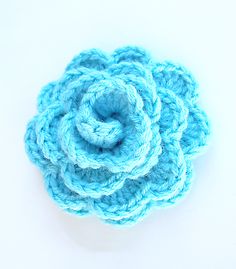 a crocheted flower is shown on a white surface with the center in blue